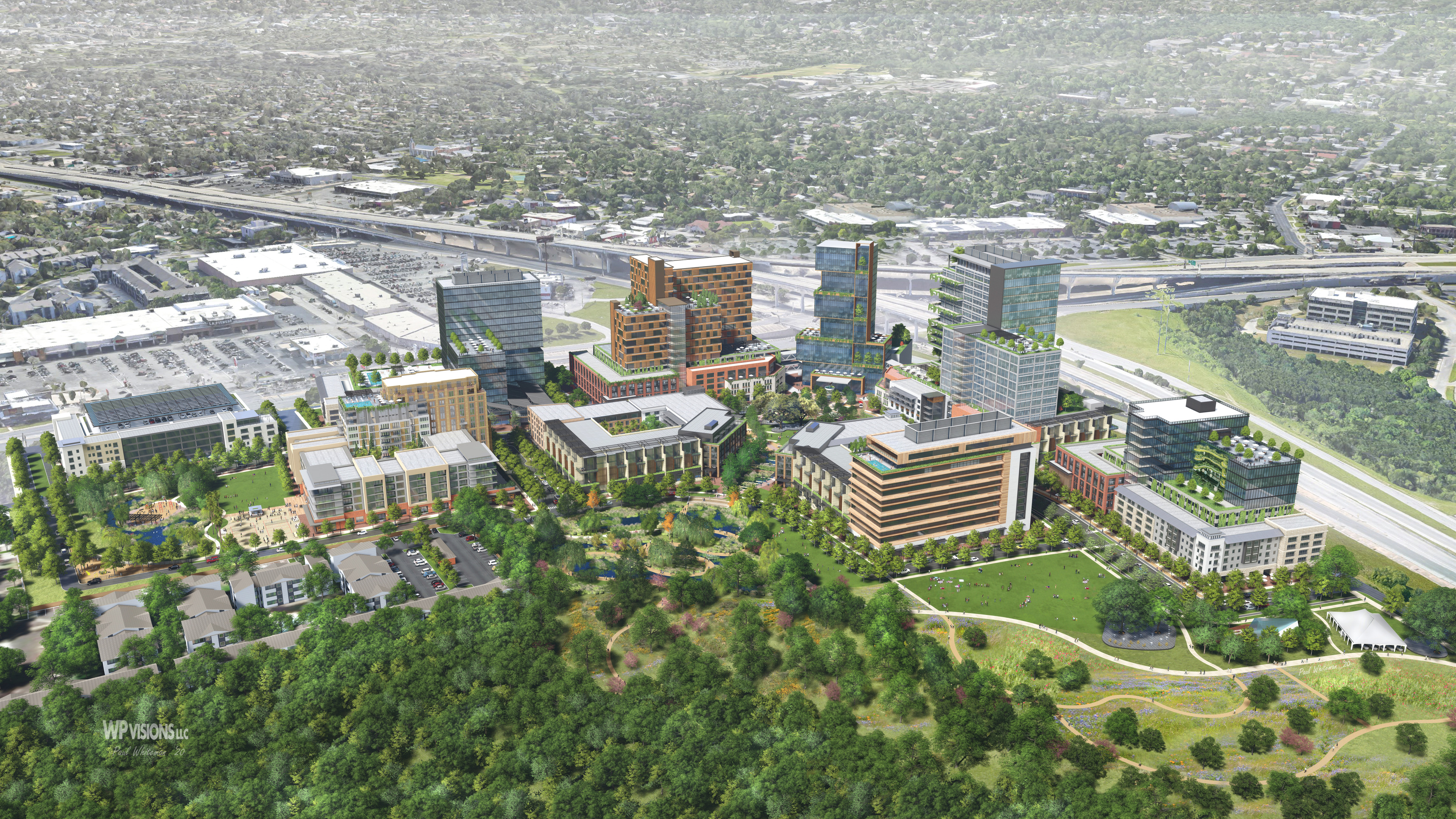 Aerial view of Brodie Oaks, a modern mixed-use development with multiple high-rise buildings, green spaces, and adjacent highways in an urban setting.