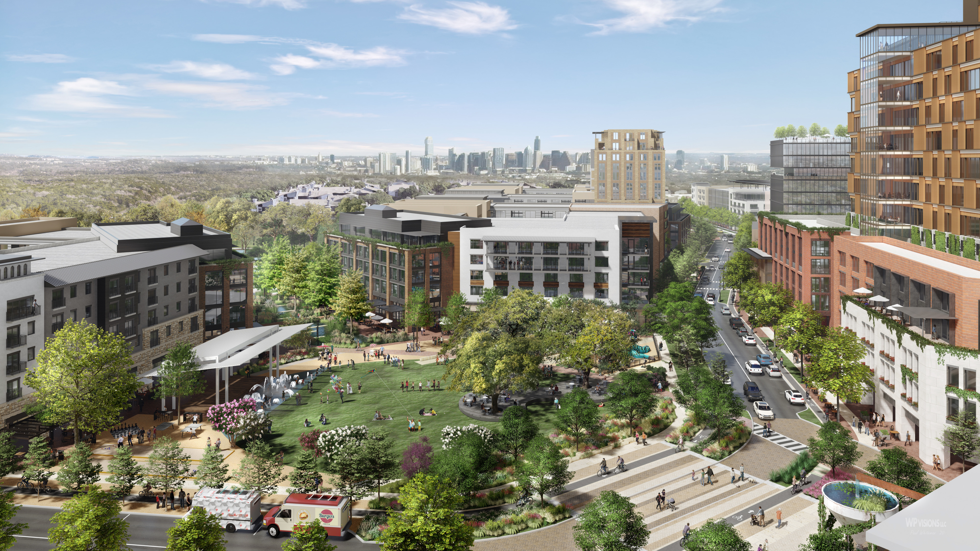 An aerial view of Brodie Oaks, a mixed-use development featuring green spaces, modern buildings, people in the park, and a distant city skyline under a blue sky.