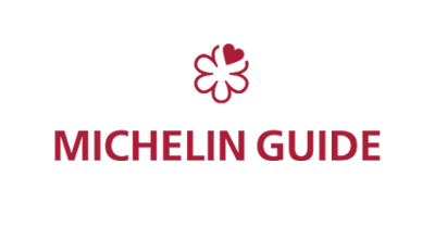 Red and white Michelin Guide logo, featuring a stylized tire man and "MICHELIN GUIDE" text below, reminiscent of the esteemed dining experiences at Stanly Ranch, Auberge Resorts Collection.