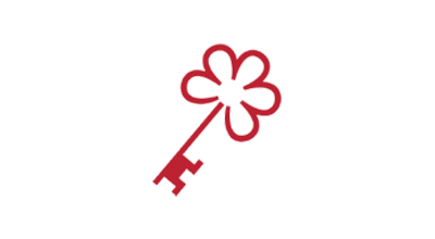 Red key with a clover-shaped top against a white background, reminiscent of the elegance found at luxury resorts like Stanly Ranch by Auberge Resorts.