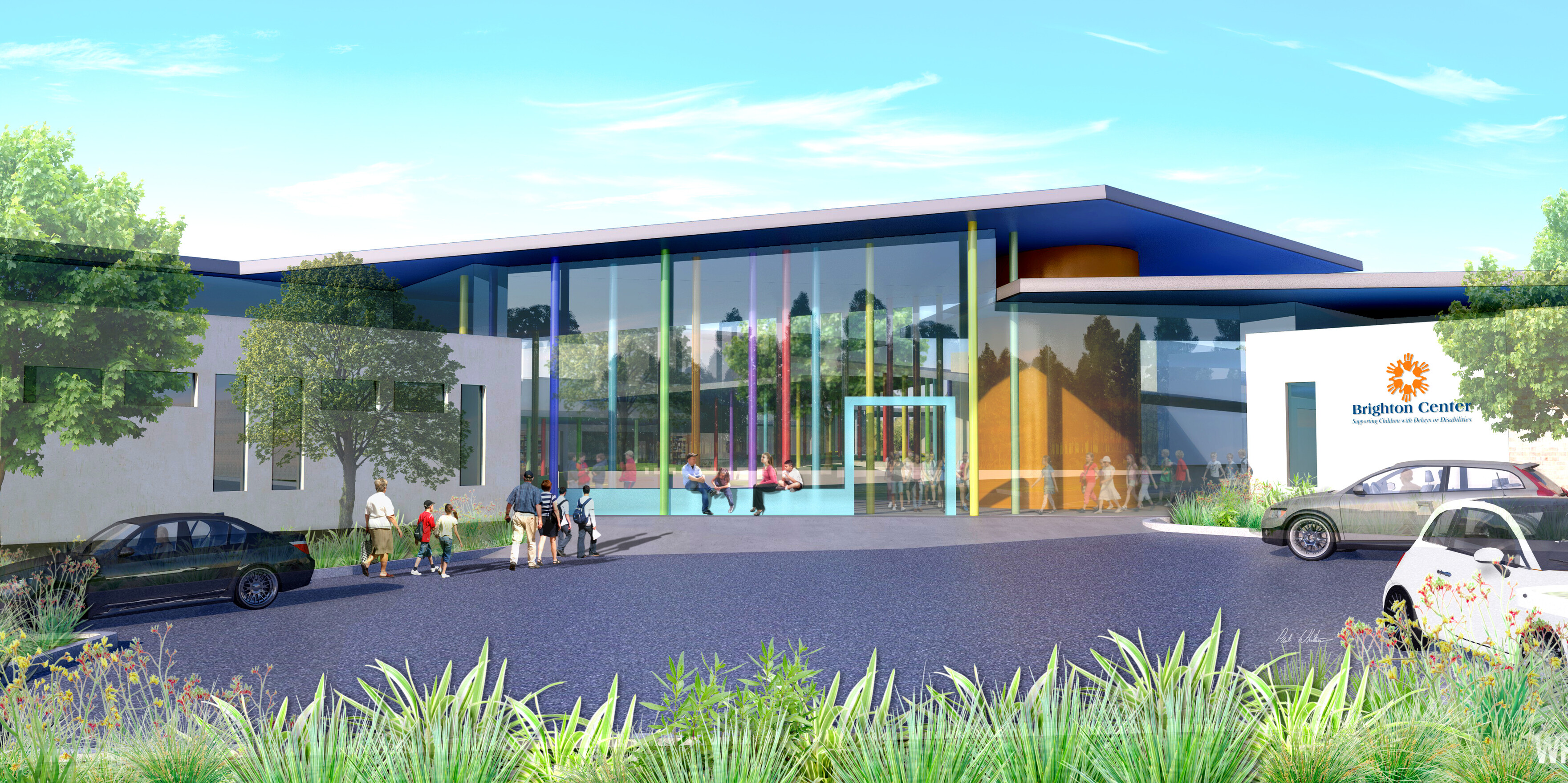 Modern building with a glass entrance and Brighton Center signage stands proudly amidst greenery, under a blue sky. Cars and people fill the parking area, showcasing the bustling activity at Higgins Campus after its recent renovation.