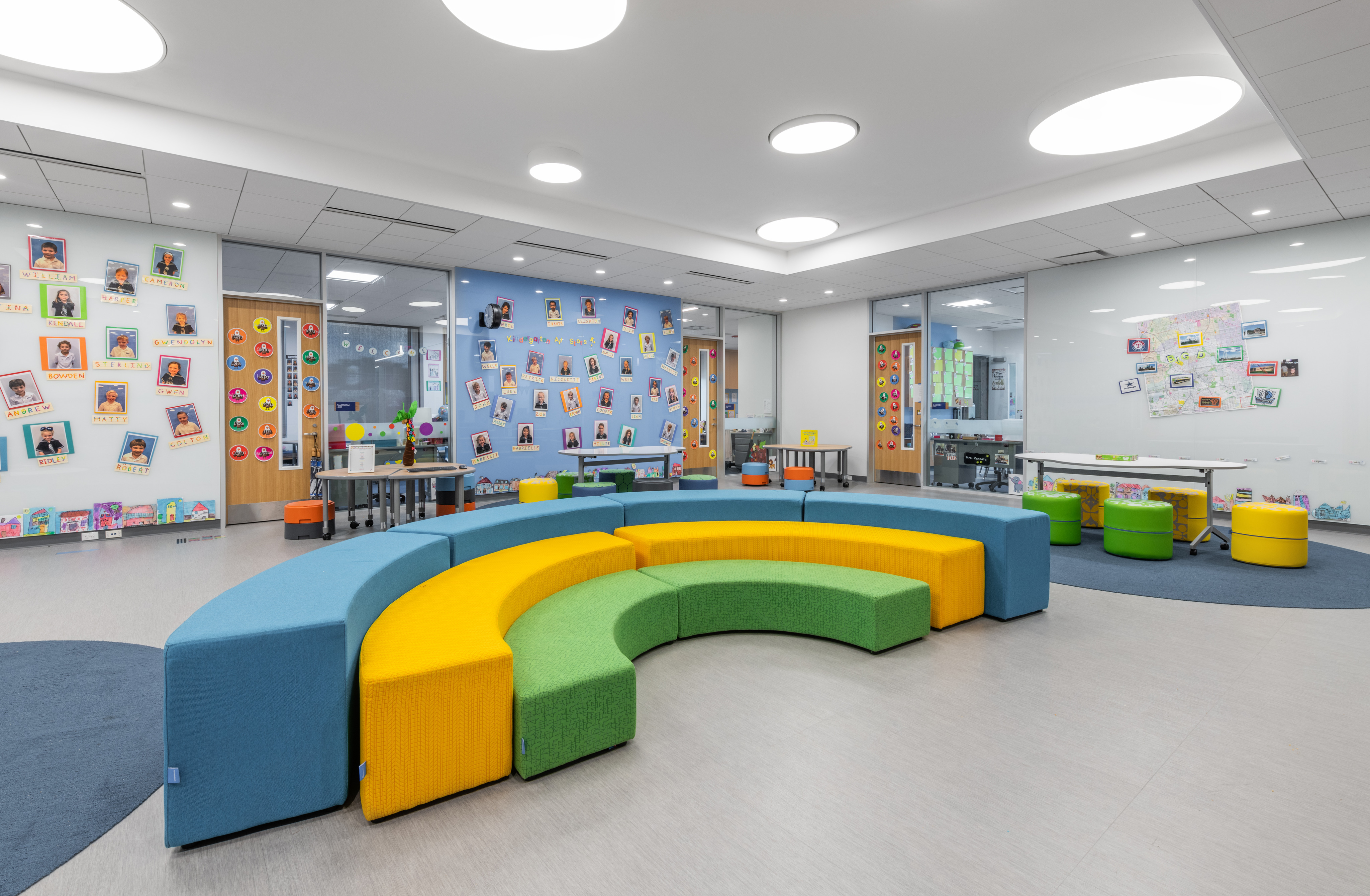 A brightly lit STEM facility at ESD Lower School features colorful, curved seating and walls adorned with children's artwork and photos.