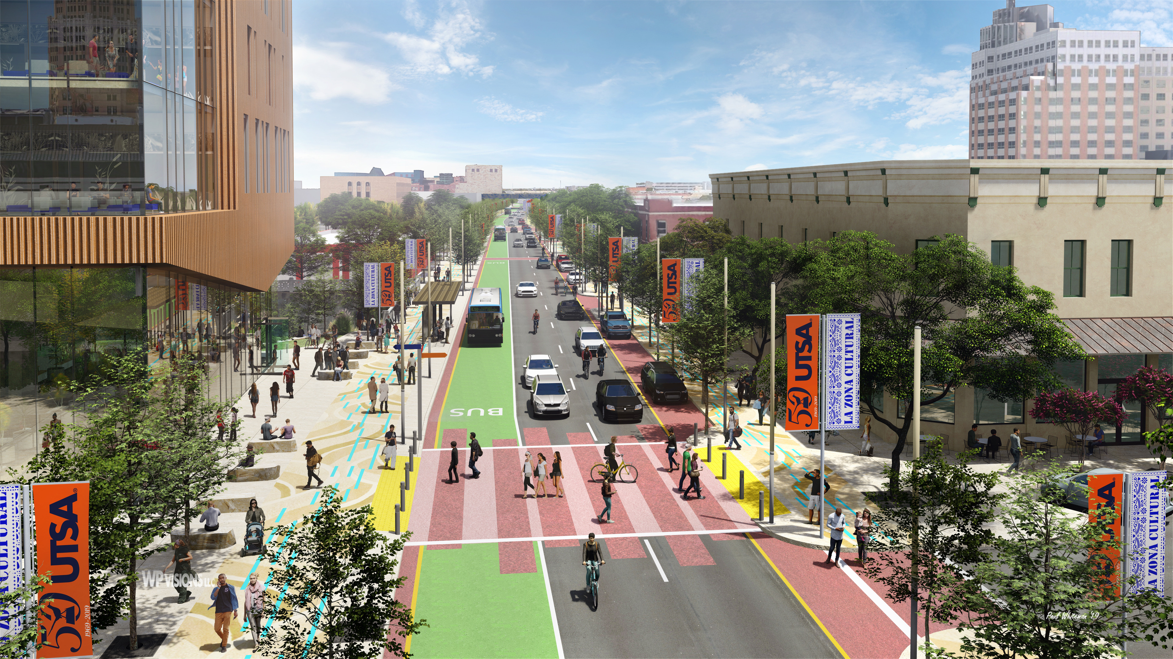 A vibrant city street, featuring bike lanes and bus lanes, is lined with buildings, trees, and banners reading "UTSA" and "50." This bustling corridor of innovation sees people walking on sidewalks, riding bikes, and cars and buses traveling along the road.