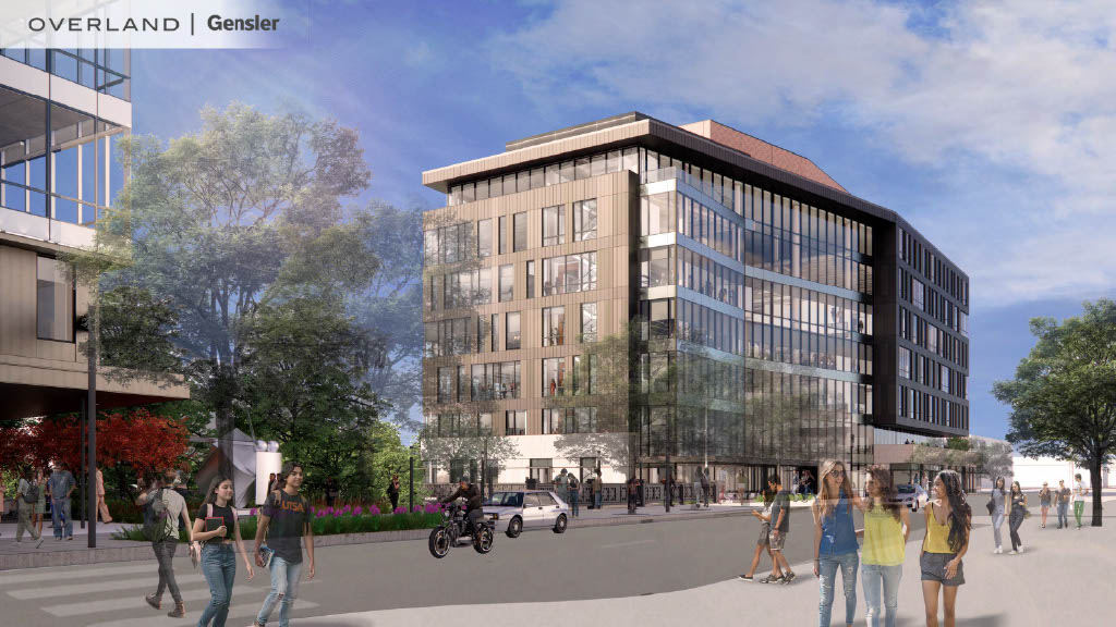 A modern multi-story building with glass windows gleams under a sunny sky. People walk and a motorcyclist rides in the foreground, capturing the essence of urban innovation. Trees and another building are also visible, shaping an inviting corridor that reflects UTSA's dynamic environment.