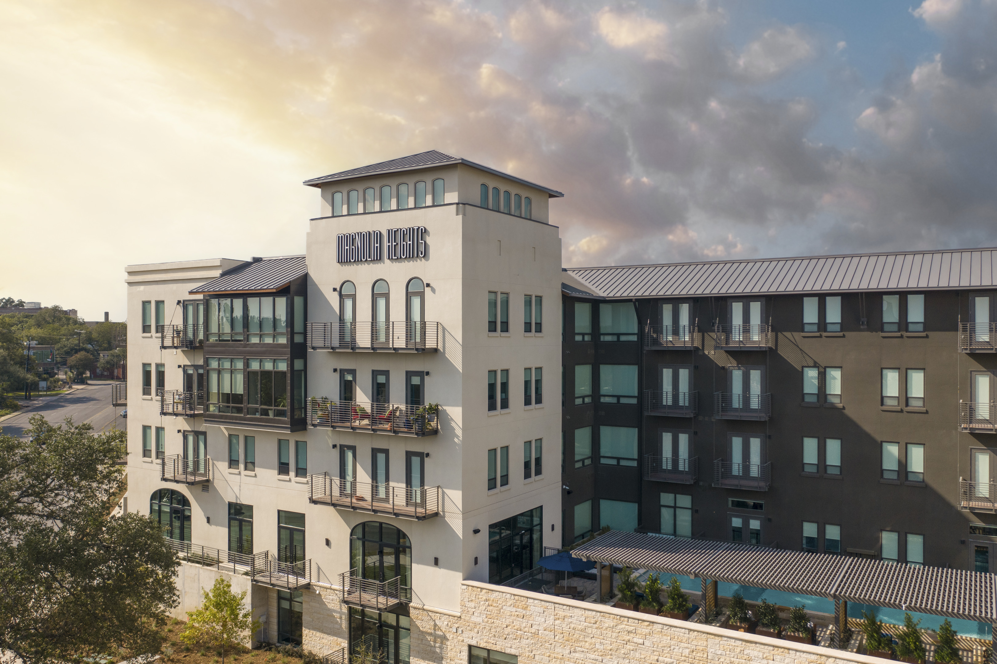 A modern four-story mixed-use development, "Oxford Heights," features a stunning blend of light and dark facades set against a cloudy sky.