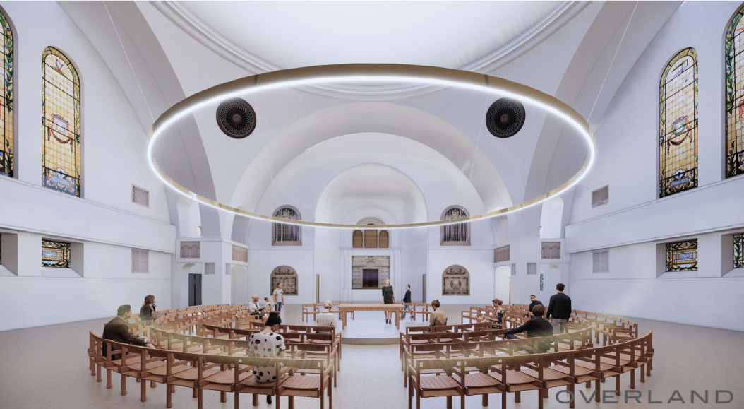 People seated in a spacious, modern church interior with circular seating, stained glass windows, and a large suspended ring light create an atmosphere of tranquility akin to an artist's thoughtful auto draft.