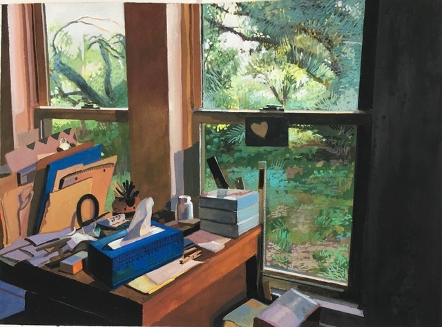 A cluttered desk by a window holds various art supplies, papers, and storage boxes. Through the window, a lush green garden thrives, reminiscent of the vibrant South Texas landscape that inspires Janet Eager Krueger and fuels the local art program's creativity.